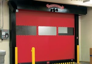 A red commercial garage door on a warehouse