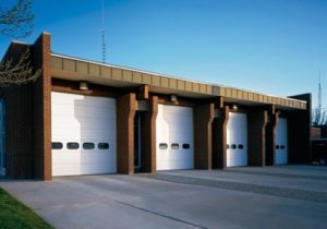 Row of white Thermacore commercial garage doors installed in a building.