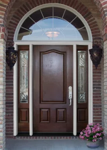 Front entry door, dark woodgrain look with decorative sidelites in a brick home, with round-top window over door.